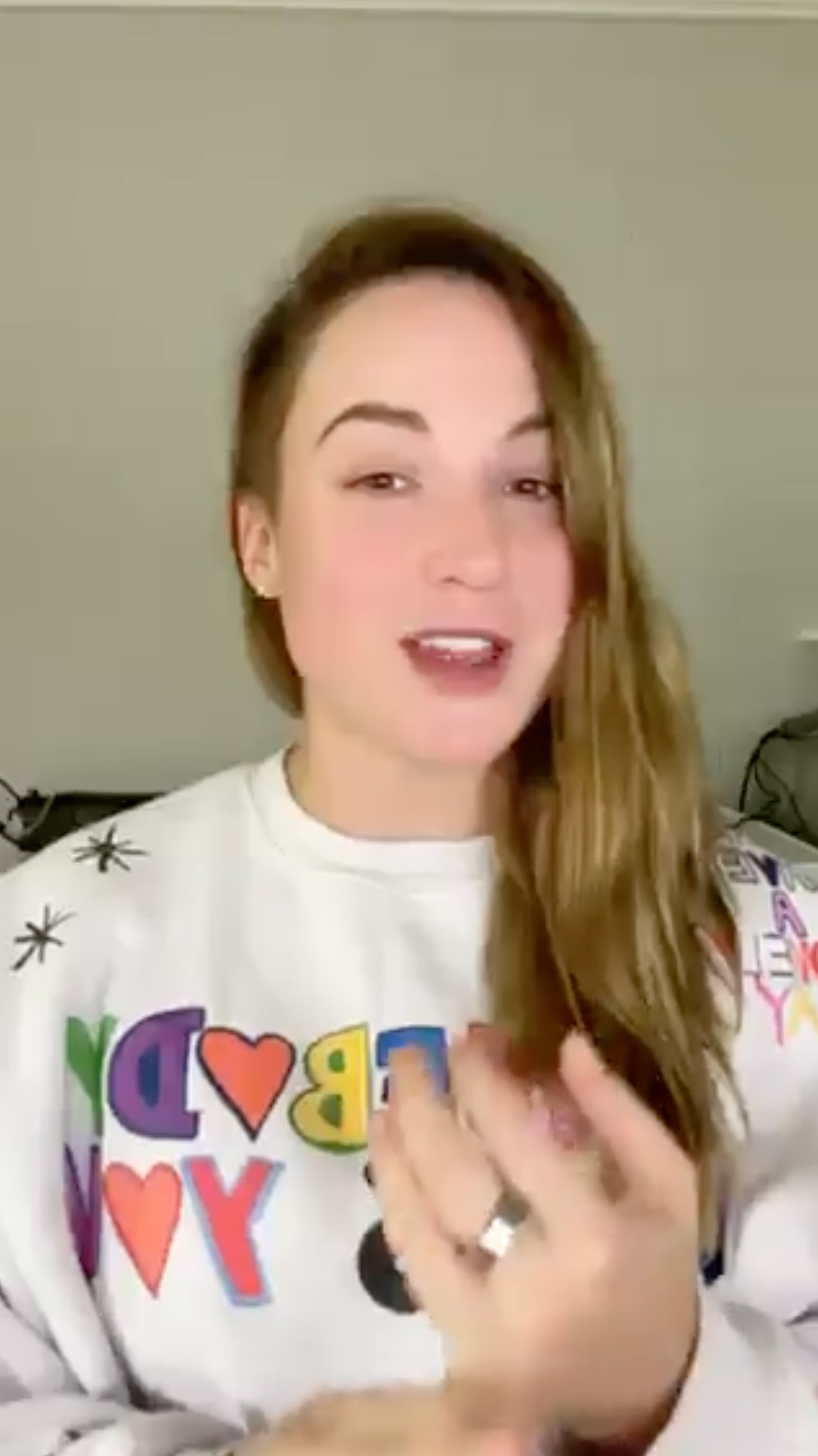 Chelsea Wise speaking to camera at home in a bright printed sweatshirt.